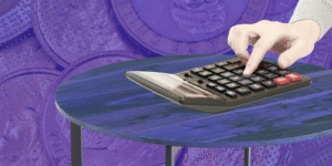 imagen de una calculadora sobre una mesa. El fondo son monedas